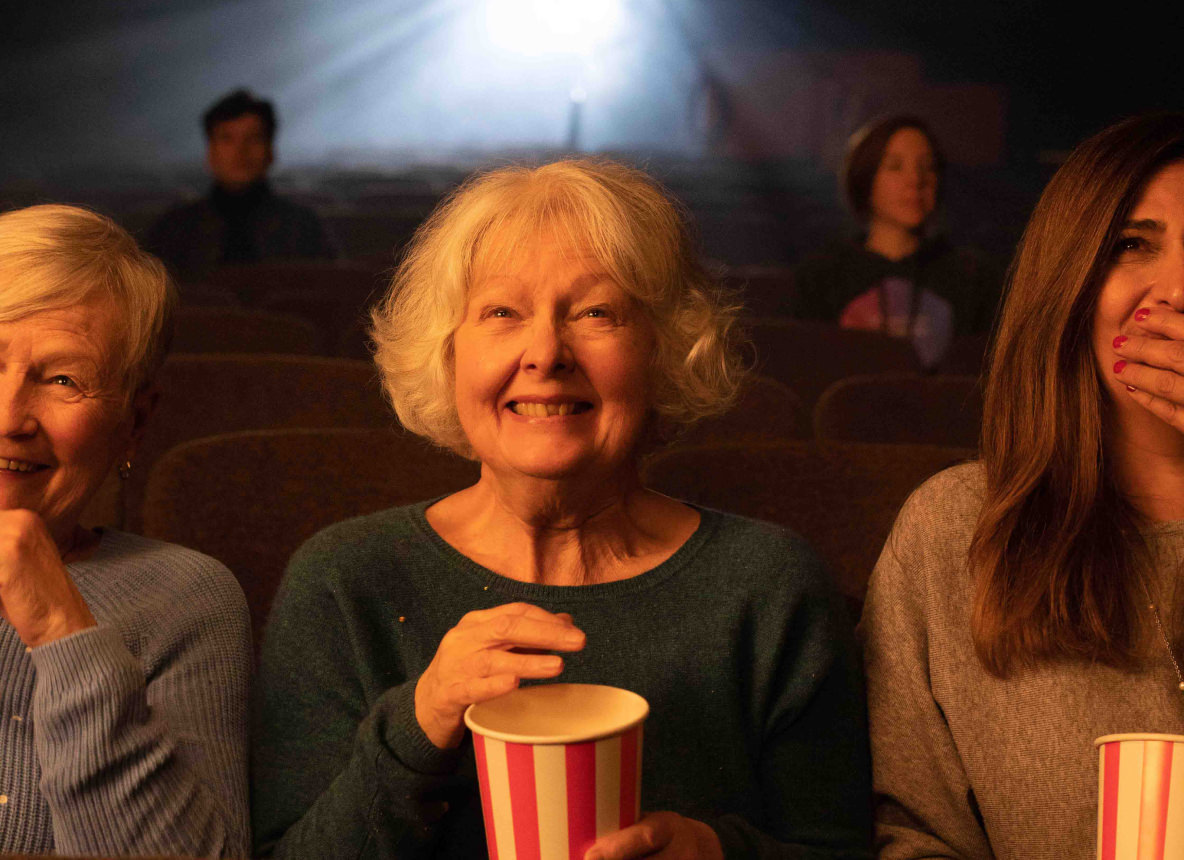 Trois femmes âgées au cinéma avec du popcorn